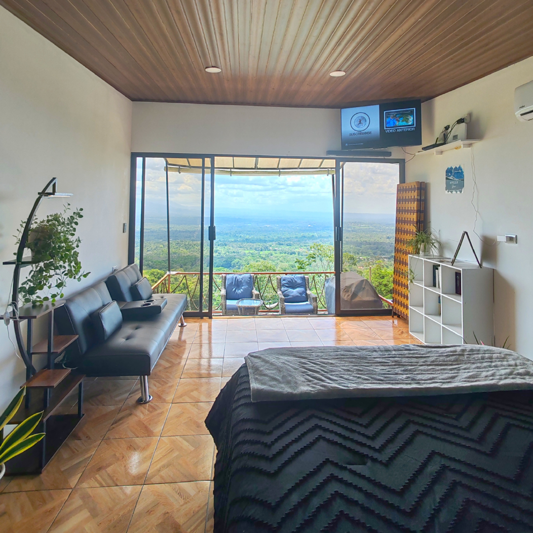 Hospedaje Hygge House cuarto con cama sillon y televisor