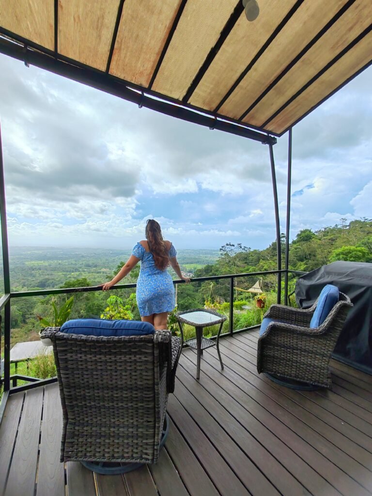 Mujer en la terrza de la cabaña con sillones y parrilla