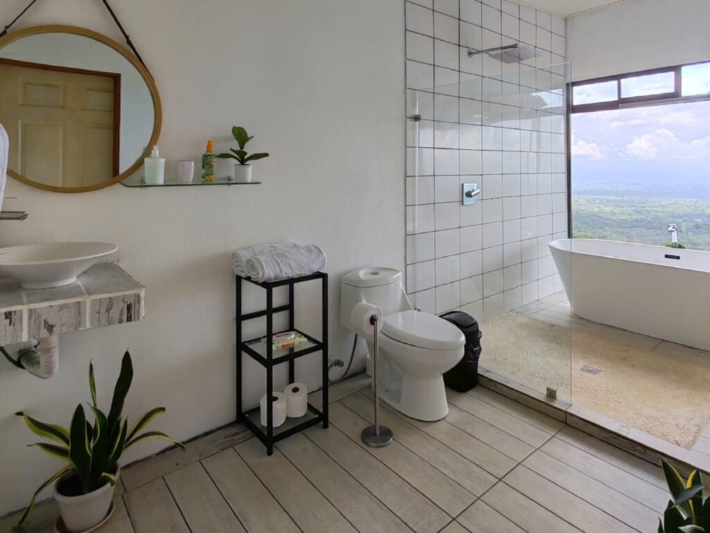 baño con servicio, lava manos, ducha y tina con vista en hygge house
